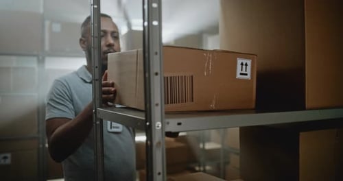 African American Warehouse Employee Loads Pallet Truck with Cardboard Boxes Transports for Shipping