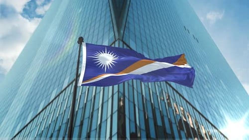 Marshall Islands Flag Waving in Front of Modern Skyscraper