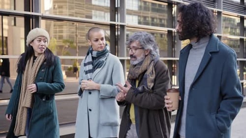 A Multiethnic Group of Cheerful Business People Walking Towards Outside a Corporate Center