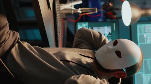 Vidéo verticale : un escroc masqué piratant un réseau informatique tard dans la nuit