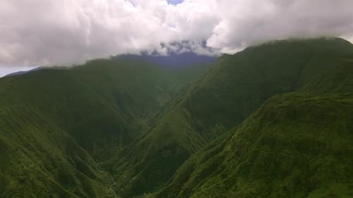 Peak of green rainforest mountain in clouds, Maui island, Hawaii, aerial view