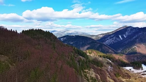 Hyperlapsus aérien rapide d'une colline rocheuse dans une forêt avec des nuages bleus après l'hiver au début du printemps