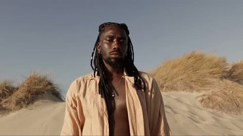 Stylish Man with Dreadlocks Posing in Desert Landscape