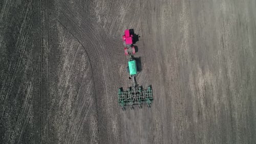 Aerial View of an Agricultural Tractor Performing Plowing Tillage for Sowing Crops A Cultivator