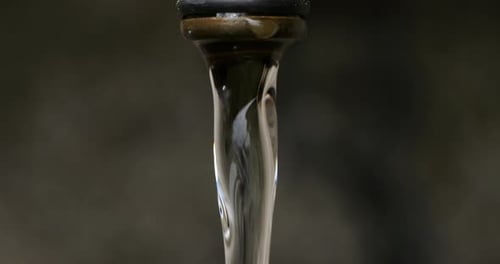 Water Flows then Drips from a Faucet