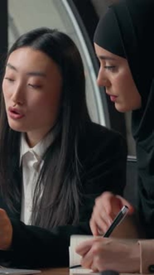 Businesswomen Collaborate on Project in Bright Modern Office