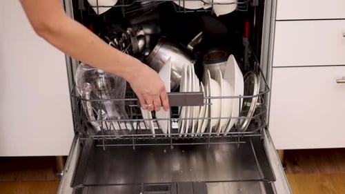 Woman Loading Dishes into Dishwasher in Modern Home