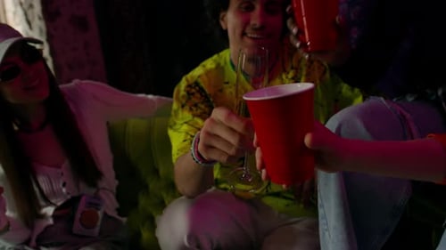 Young Adults Toasting Drinks at Indoor Night Party