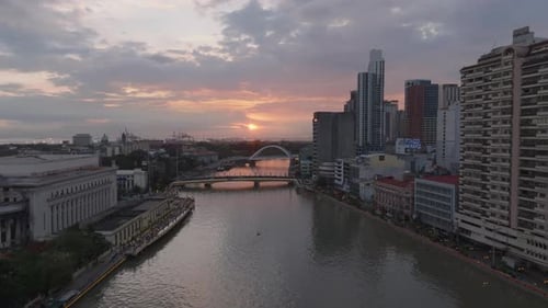 Forwards Fly Above River in City Against Sunset Sky High Rise Buildings on Waterfront Manila