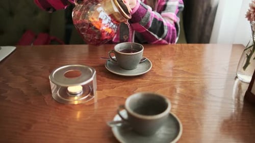 Pouring Tea Into Teacup with Candle Warmer