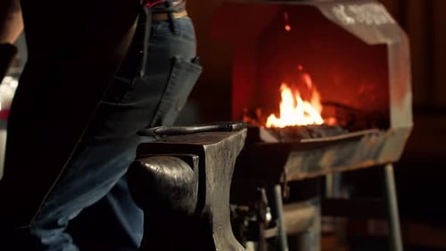Blacksmith Shaping Glowing Metal on Anvil
