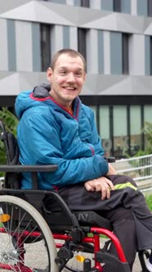 Man sitting in wheelchair smiling in urban setting