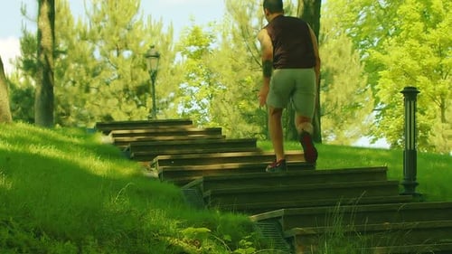 Man Running Up Stairs in a Green Park