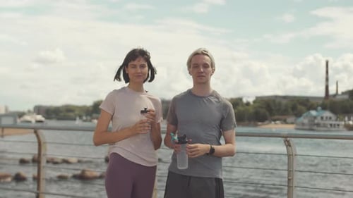 Athletic Man and Woman Smiling on Waterfront