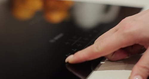 Woman Hand Turn on Induction Stove to Cook Finger Touching Sensor Button on Induction or Electrical