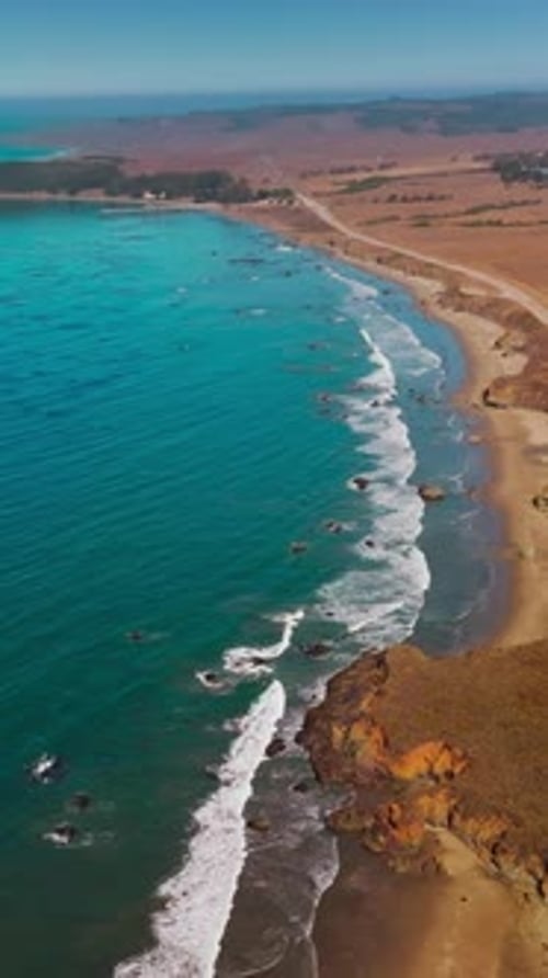 Dry deserted land bordering with blue waters of ocean. Highway through the coastline of Morro Bay