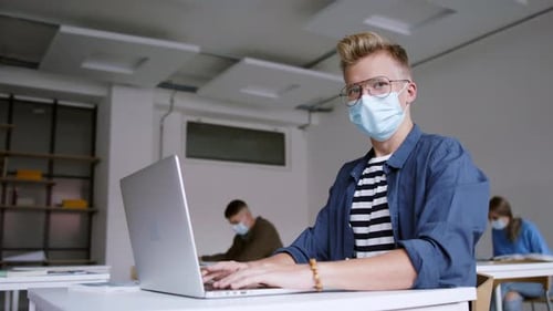 Young Students with Face Masks at Desks at College or University, Coronavirus