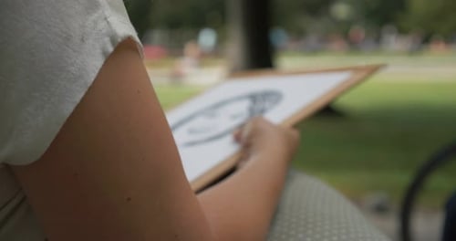 A girl drawing a woman in the park