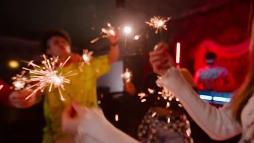 Group of Diverse Young People Dancing with Glowing Sparks of Firework