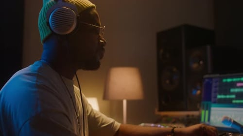 Sound Engineer Adjusting Audio Mixer in Studio