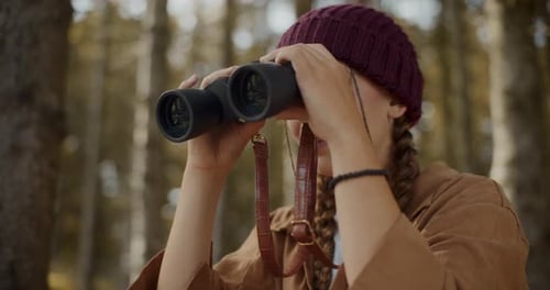 Exploradora feminina pesquisando através de binóculos