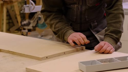 Carpenter Assembles Furniture in a Carpentry Workshop Creating Furniture By Hand