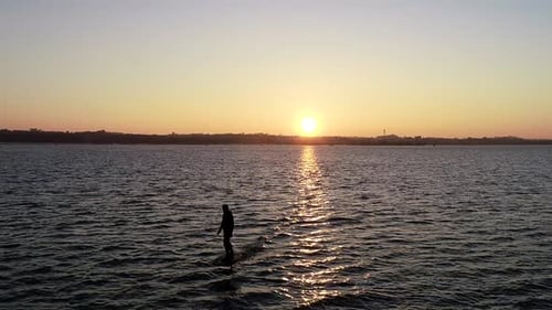 E Foil Sunset boating on the water. Paddleboard, stand-up surfing on electric foil. Aerial drone sho