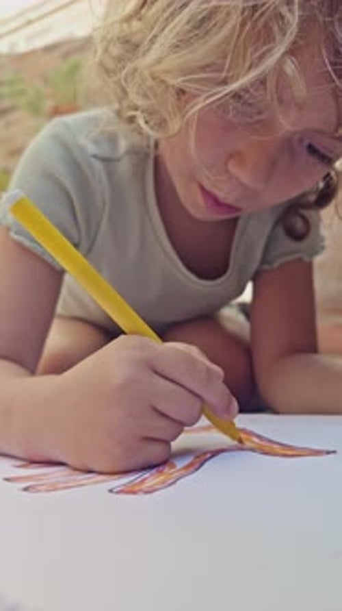 Young Girl Using Coloured Pens Drawing Picture in Vertical