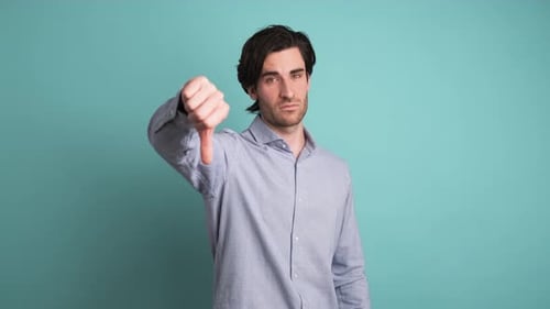 Upset Man Showing Thumb Down in Blue Studio