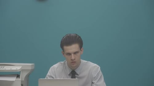 An Office Worker is Sitting at His Desk with a Laptop Next to Him is a Freak Woman with a Electro