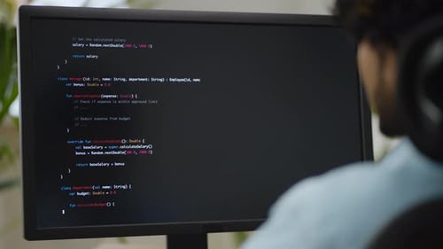Programmer Typing Code at Computer Workstation