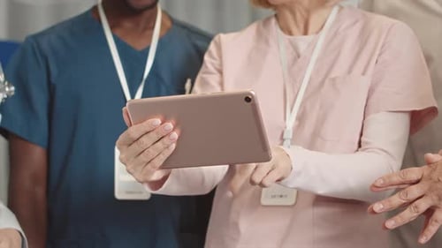 Medical Team Collaborating with Tablet in Hospital
