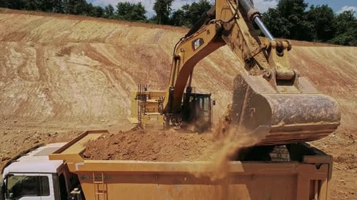 Excavator Filling Dump Truck with Dirt Aerial Shot