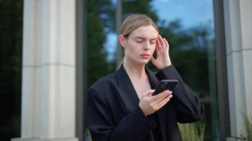 Businesswoman With Smartphone Looks Stressed and Upset