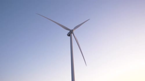 Close up shot of wind turbine slowly spinning during a sunset/sunrise. Concept of clean and green en
