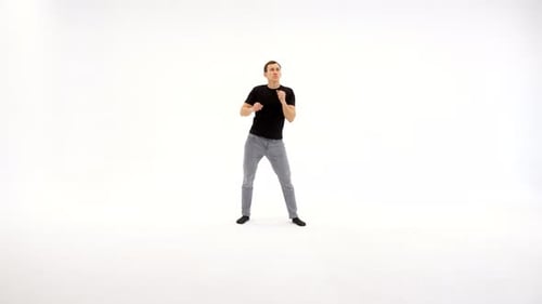 Man Dancing in White Studio with Hands Up