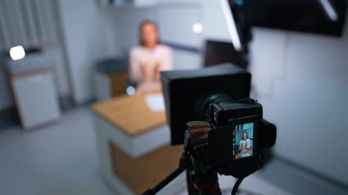 Blogger speaking to camera sitting at desk. Professional camera footage of content. Close up.
