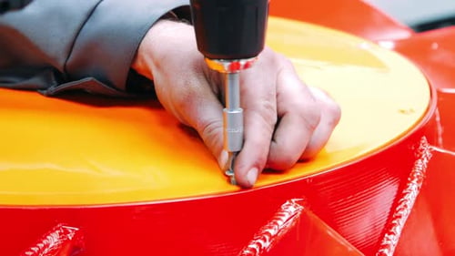 Using of Electric Screwdriver in Assemble Workshop. Worker with Screwdriver and Bit