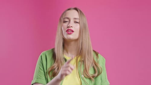 Smiling Pretty Woman with Finger on Lips Shhh Secret Silence Pink Studio