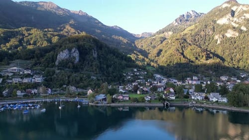 Aerial view of a Swiss village nestled at the base of the majestic Mountain Alps, overlooking the na