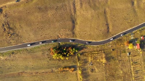 Drone aérien au ralenti, vue 4k d'une route asphaltée sinueuse et de voitures en mouvement à l'automne
