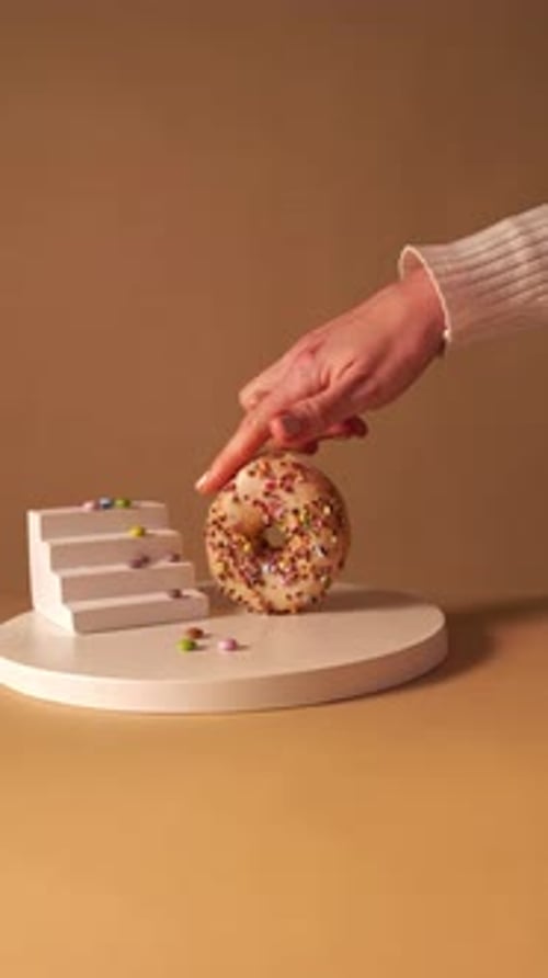 Hand Paying and Taking Donut on Minimal Pedestal Studio Background