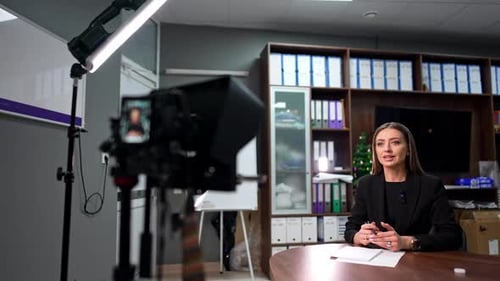 Female speaker sitting in the office at the desk.