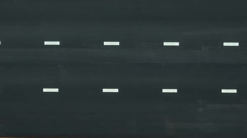 Aerial drone view of a newly paved asphalt road with a moving car.