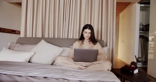 Happy Pretty Female Working From Home on Key Laptop Computer From Bedroom