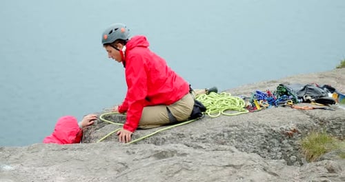 Climber helps friend with gear on rocky cliff in Yosemite national park slow motion