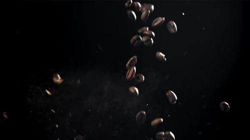 Die Kaffeebohnen fallen in die funktionierende Mühle, gefilmt mit einer Hochgeschwindigkeitskamera mit 1000 Bildern pro Sekunde