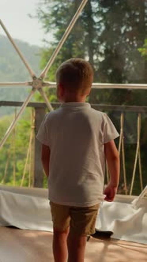 Child Blond Boy Walks to Glass Dome at Glamping Terrace