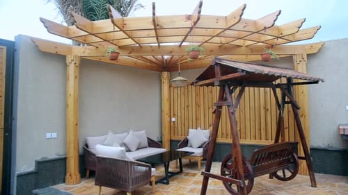 Deck patio outdoor lounge area, establishing shot of wooden pergola space, nobody