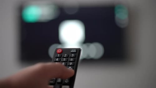 Closeup Remote Control with Male Caucasian Hand Pressing Buttons Switching Channels Closeup